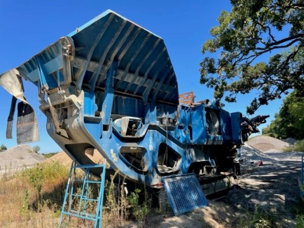 A rock crusher in a field.