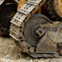 big crawler wheel, The Crawler close up , muddy crawler chain detail in earthy ambiance, Well used excavator tracks closeup